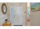 Bright foyer with a white front door, mirror, artwork, and adjacent window fills the area with natural light at 6920 74Th Street E Cir, Bradenton, FL 34203