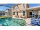 This screened-in pool has outdoor seating and a grill for outdoor entertaining with lake views at 6920 74Th Street E Cir, Bradenton, FL 34203