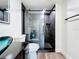 Remodeled bathroom featuring glass shower with black marble-style tile at 712 N Elm St, Englewood, FL 34223