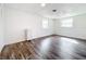 Bright bedroom with wood-look floors, white walls, closet and two windows offering natural light at 712 N Elm St, Englewood, FL 34223