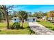 Charming single-story home with a well-maintained yard, light blue siding and a gravel driveway at 712 N Elm St, Englewood, FL 34223