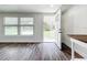 Inviting living room with wood-look floors, featuring large windows and an open doorway at 712 N Elm St, Englewood, FL 34223