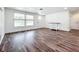 Bright living room with wood-look floors, enhanced by natural light streaming through a large window at 712 N Elm St, Englewood, FL 34223
