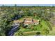 Expansive aerial view of landscaped property featuring a large home, mature trees, and lush green lawn at 7820 Seville Cir, Bradenton, FL 34209