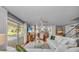 Bright living room with white sofa, wood floors, and view of the pool and back yard at 7820 Seville Cir, Bradenton, FL 34209