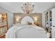 Elegant main bedroom features a large chandelier, hardwood floors, and neutral paint at 7820 Seville Cir, Bradenton, FL 34209