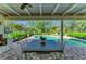 Outdoor patio with dining table and a view of the sparkling in-ground pool and lush landscaping at 7820 Seville Cir, Bradenton, FL 34209