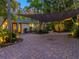 Paver driveway with shade sail, enhanced by lush landscaping, creates a welcoming entry to this charming home at 1330 N Lockwood Ridge Rd, Sarasota, FL 34237