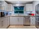 Bright, modern kitchen featuring stainless steel appliances, white cabinets, and a window over the sink at 1330 N Lockwood Ridge Rd, Sarasota, FL 34237