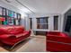 Modern living room with red leather seating and neutral tile flooring at 1330 N Lockwood Ridge Rd, Sarasota, FL 34237