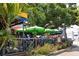 Outdoor seating area with green umbrellas providing shade, surrounded by lush greenery and a relaxed vibe at 147 Whispering Sands Dr # V29, Sarasota, FL 34242