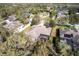 An aerial view showcases a home with a screened lanai, mature landscaping, and a spacious backyard in a verdant neighborhood at 2111 152Nd E Ct, Bradenton, FL 34212