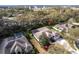 This aerial view highlights a home with a screened patio, mature trees, and well-maintained landscaping in a suburban setting at 2111 152Nd E Ct, Bradenton, FL 34212