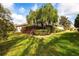 Spacious backyard featuring a large tree, garden beds and screened-in pool enclosure at 2111 152Nd E Ct, Bradenton, FL 34212