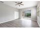 Bedroom features gray floors, a ceiling fan, and sliding glass doors to a screened patio with a pool at 2111 152Nd E Ct, Bradenton, FL 34212