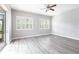 Bright bedroom with luxury vinyl plank flooring, shuttered windows, and access to a balcony at 2111 152Nd E Ct, Bradenton, FL 34212