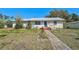 Charming single-story home featuring a metal roof, a blue front door, and a simple landscaped yard at 2302 8Th W Ave, Bradenton, FL 34205
