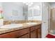 Bathroom featuring double sinks with granite countertops, wood cabinets, a mirror and shower at 2347 Richwood Pike Dr, Ruskin, FL 33570