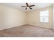 Comfortable bedroom featuring plush carpeting, ceiling fan, and a bright window, creating a cozy and inviting atmosphere at 2347 Richwood Pike Dr, Ruskin, FL 33570