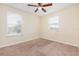 This bedroom offers carpet flooring and natural light from two windows with a ceiling fan at 2347 Richwood Pike Dr, Ruskin, FL 33570
