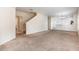 Spacious living room featuring neutral carpet, staircase, and an open layout to the kitchen and dining area at 2347 Richwood Pike Dr, Ruskin, FL 33570