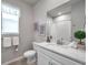 Bathroom with marble vanity, white cabinetry, and shower with white tile surround at 3747 Laughing Dove Ave, Sun City Center, FL 33573