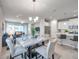 Bright dining area with a marble table, chandelier, and open floor plan to living room and kitchen at 3747 Laughing Dove Ave, Sun City Center, FL 33573