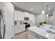 Modern white kitchen with stainless steel appliances, an island with a sink, and white cabinets at 3747 Laughing Dove Ave, Sun City Center, FL 33573