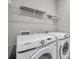 Convenient laundry room featuring a side-by-side washer and dryer and wire shelving at 3747 Laughing Dove Ave, Sun City Center, FL 33573