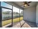 A screened-in patio with brick flooring and a ceiling fan, offering a comfortable outdoor living space at 3747 Laughing Dove Ave, Sun City Center, FL 33573