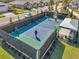 A pickleball court surrounded by a black fence, featuring a green and blue surface and shaded seating at 3747 Laughing Dove Ave, Sun City Center, FL 33573