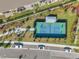 Aerial view of a well-maintained pickleball court with players, a covered seating area, and parking nearby at 3747 Laughing Dove Ave, Sun City Center, FL 33573