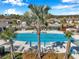 A community pool surrounded by palm trees, lounge chairs and luxurious upscale neighborhood homes at 3747 Laughing Dove Ave, Sun City Center, FL 33573