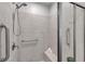 Modern shower with tiled walls, a bench, grab bars, and glass doors at 3747 Laughing Dove Ave, Sun City Center, FL 33573