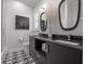 Bathroom featuring patterned tile floor, black marble countertops, and black framed mirrors at 400 N Washington Dr, Sarasota, FL 34236