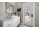 Bathroom featuring a white sink vanity with marble countertops, a decorative mirror, and an exterior door at 400 N Washington Dr, Sarasota, FL 34236
