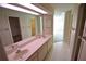 Bright bathroom featuring a double sink vanity, tiled floors, and an adjacent room at 5244 Marsh Field Rd # 6, Sarasota, FL 34235