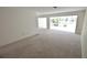 Spacious living room featuring carpeted floors, a large window, and neutral walls at 5244 Marsh Field Rd # 6, Sarasota, FL 34235