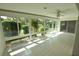 Bright sunroom with tile flooring and panoramic views of the landscaped outdoors at 5244 Marsh Field Rd # 6, Sarasota, FL 34235