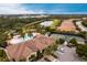 Aerial view of community amenities including pool, tennis courts, and clubhouse, surrounded by lush landscaping and pond at 5814 Cavano Dr, Sarasota, FL 34231