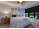 Serene bedroom with a large window, neutral walls, ceiling fan, and stylish lamps at 5814 Cavano Dr, Sarasota, FL 34231