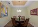 Dining room featuring tray ceiling, wood floors, round table, and stylish decor with art at 5814 Cavano Dr, Sarasota, FL 34231