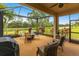 Relaxing screened lanai with seating area and views of the surrounding lake and landscaping at 5814 Cavano Dr, Sarasota, FL 34231