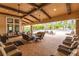 Spacious outdoor lounge area with comfortable seating, ceiling fans, and a view of the pool at 5814 Cavano Dr, Sarasota, FL 34231