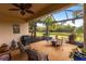Screened lanai featuring seating area with ceiling fan and views of the lush, landscaped backyard at 5814 Cavano Dr, Sarasota, FL 34231
