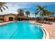 Stunning community pool surrounded by lush landscaping, palm trees, and cozy lounge chairs for relaxation at 5814 Cavano Dr, Sarasota, FL 34231