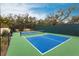 Well-maintained tennis court with a net, set in a lush, green environment for recreational enjoyment at 5814 Cavano Dr, Sarasota, FL 34231