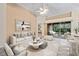 Bright living room featuring a modern sofa, stylish décor, and sliding doors to the outdoor space at 6211 Skyward Ct, Bradenton, FL 34203