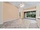 Spacious living room with neutral tones, tile flooring, and sliding glass doors to lanai at 6211 Skyward Ct, Bradenton, FL 34203