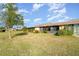 The backyard is a bright, open green space, with trees and a covered back porch visible at 6314 29Th W Ave, Bradenton, FL 34209
